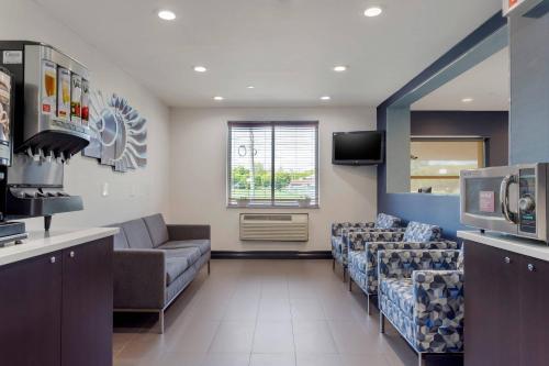a waiting room with couches and a tv in a hospital at Avion Inn Near LGA Airport, an Ascend Collection Hotel in Queens