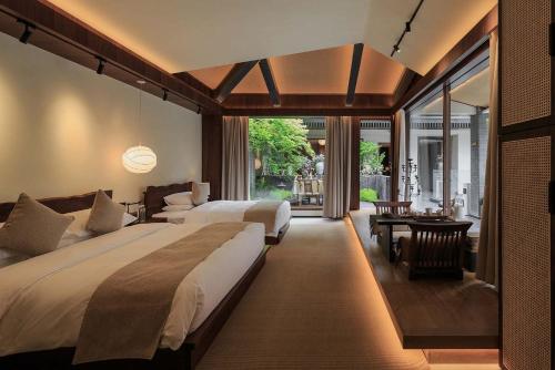 a bedroom with two beds and a desk and a table at Return Courtyard Hotel in Chengdu