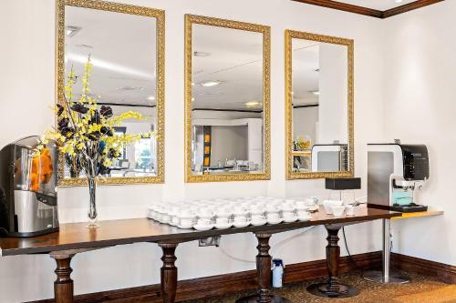 Una mesa con un grupo de espejos en una pared. en Hotel Elms Christchurch, an Ascend Collection Hotel, en Christchurch