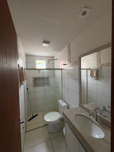 サンタ・クルース・カブラーリアにあるAp em Cor vermelha - perto do mar da cultura Pataxóのトイレ、洗面台、鏡のあるバスルーム