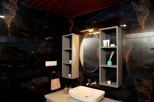 a bathroom with a sink and a mirror at Tranquility Home Stay Coorg in Kutta