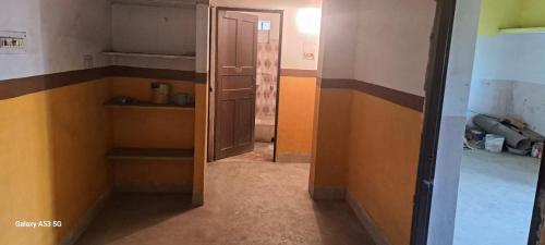 een lege kamer met een open deur en een kamer met een gang bij Maa Durga Apartment in Dhanbad