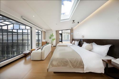 a bedroom with two beds and a large window at Shangri La cuckoo hotel in Shangri-La