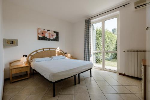 a bedroom with a bed and a large window at Il Colombaro in Salò