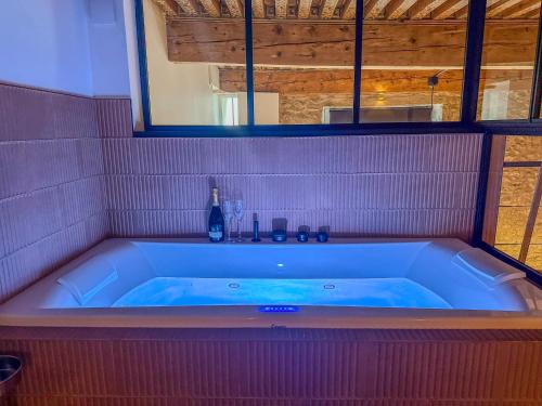 a bath tub in a room with a blue tub at Le Refuge de la Bastille - Jacuzzi in Grenoble