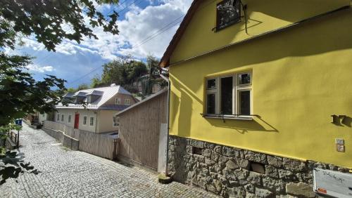 un edificio amarillo con una ventana en una calle en Romantic House in Botanic Garden, en Banská Štiavnica