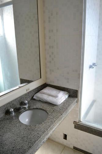 a bathroom counter with a sink and a mirror at Hotel Barao Da Taquara in Rio de Janeiro