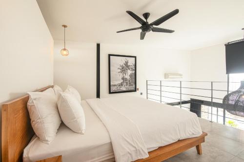 a bedroom with a bed with a ceiling fan at Expansive Loft 200m From Canggu Beach Haven in Canggu