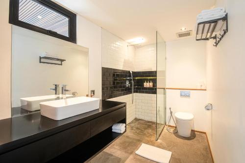 a bathroom with a sink and a glass shower at Expansive Loft 200m From Canggu Beach Haven in Canggu