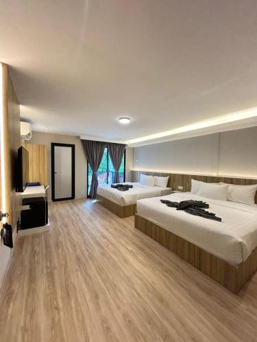 a hotel room with two beds and a television at Alva Boutique Chalet Pangkor in Pangkor