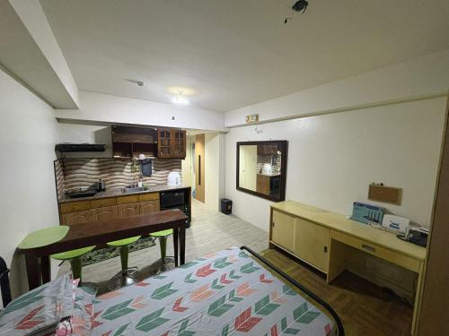a room with a kitchen and a bed and a desk at AMAIA Condo Mandaue in Mandaue City