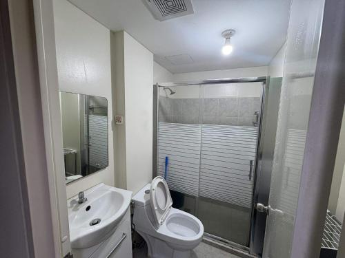 a bathroom with a toilet and a sink and a shower at AMAIA Condo Mandaue in Mandaue City