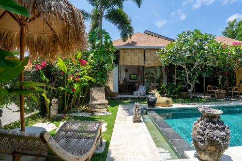 a backyard with a swimming pool and a house at La Kreyiol in Uluwatu