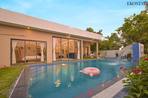 a swimming pool in the backyard of a house at EKOSTAY Luxe - Ivory Coast Villa in Alibaug