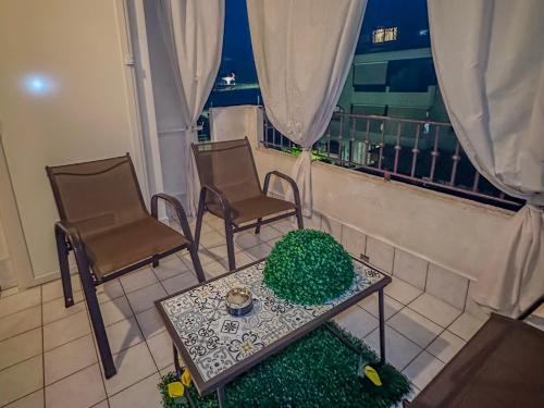 Zimmer mit 2 Stühlen, einem Tisch und einem Balkon in der Unterkunft La Cola Cola in Gravina in Puglia