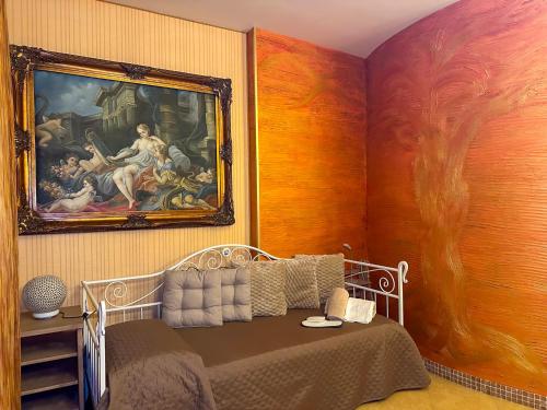 ein Schlafzimmer mit einem Bett und einem Gemälde an der Wand in der Unterkunft La Cola Cola in Gravina in Puglia