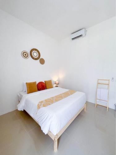a bed in a white room with a white wall at Yan Loft in Uluwatu