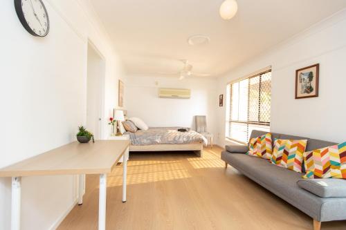 a living room with a couch and a table at Cozy Studio Suite in House - Private Kitchen Bath in Rochedale