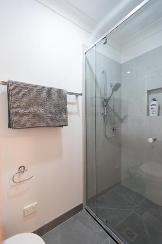 a bathroom with a glass shower with a toilet at Cozy Studio Suite in House - Private Kitchen Bath in Rochedale