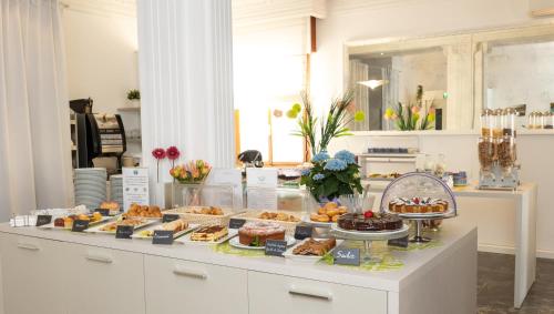 un buffet di dolci e pasticcini su un bancone di Hotel Smeraldo a Lido di Jesolo