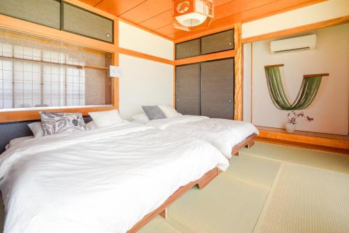 大崎市楓 -Kaede-的一间房间里有两张床的卧室