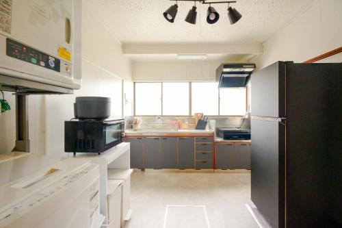 大崎市楓 -Kaede-的厨房配有黑色冰箱和水槽