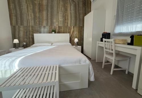 a bedroom with a white bed and a desk at Da Marianna in Castelnuovo Rangone