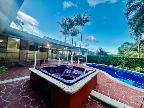 RochedaleA Beautiful room in Mackenzie Brisbane的带游泳池的房子前面的热水浴缸