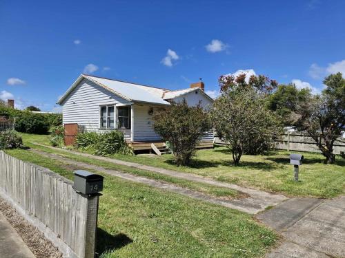 ein weißes Haus mit einem Zaun im Hof in der Unterkunft Seabreaze cottage sleeps 6 in Portland