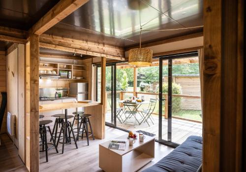 uma cozinha em plano aberto e sala de estar com um sofá azul em Huttopia Arcachon em Arcachon