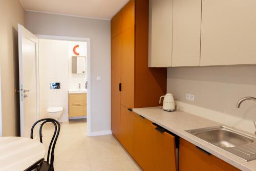 a kitchen with white cabinets and a sink and a toilet at Słoneczna in Sieraków