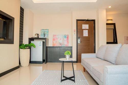 a living room with a couch and a table at Lulu Hotel in Ban Phlu Yai
