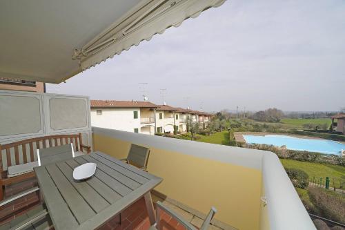 a balcony with a table and a view of a pool at Blu Garda View in Polpenazze del Garda