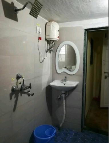 a bathroom with a sink and a mirror at Tuka Maka Homestay in Malvan