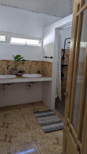 a bathroom with two sinks and a window at Kaz Kreol in Trou d'Eau Douce
