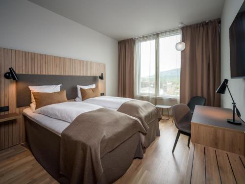 a hotel room with a large bed and a desk at Quality Airport Hotel Værnes in Stjoerdal