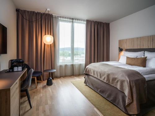 une chambre d'hôtel avec un lit, un bureau et une fenêtre dans l'établissement Quality Airport Hotel Værnes, à Stjoerdal