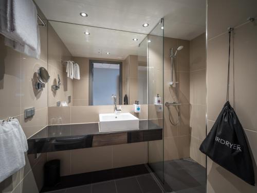 a bathroom with a sink and a glass shower at Quality Airport Hotel Værnes in Stjoerdal