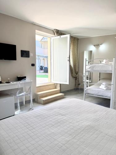 a bedroom with a bed and a desk and a window at ALDIVA ROOMS in Torvaianica