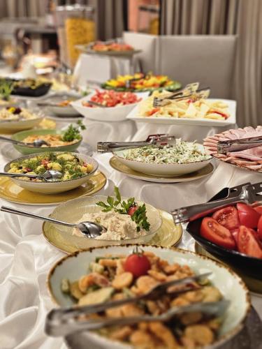 uma mesa longa com pratos de comida em Hotel Dumbrava em Bacău