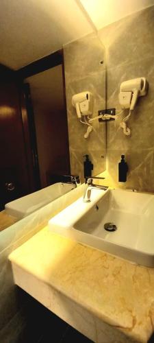 a bathroom with a white sink and a mirror at White Orchid in Cox's Bazar