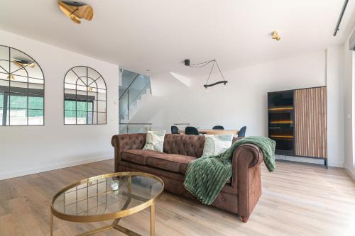 un soggiorno con un divano e un tavolo di vetro di La Casa Dorada a Santander