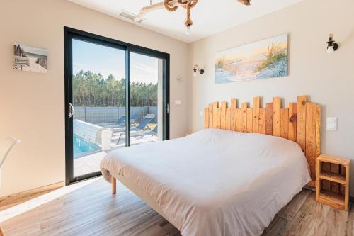 a bedroom with a bed and a large window at Belle Villa, Evasion Landaise in Azur