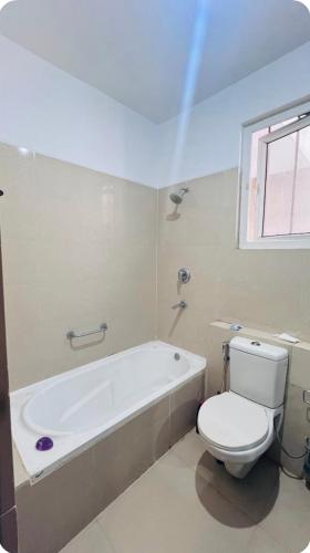 a bathroom with a white tub and a toilet at Vardaan Luxury Villa in Mohali