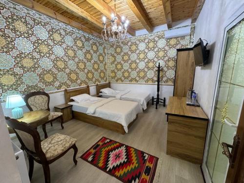a bedroom with a bed and a table and chairs at Asia Central Boutique in old city in Bukhara