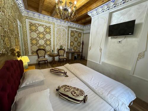a bedroom with a bed and a tv on the wall at Asia Central Boutique in old city in Bukhara
