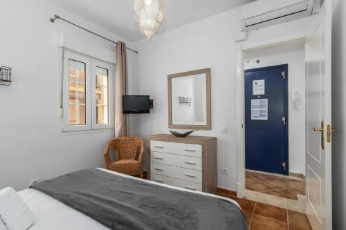 a bedroom with a bed and a mirror and a blue door at Playa Grande - Playa Punta del Moral PPHG150P104 in Isla del Moral