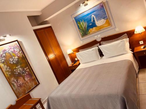 a bedroom with a bed and a painting on the wall at Triton Hotel Piraeus in Piraeus
