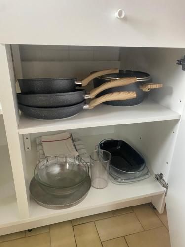 a shelf with plates and utensils in a kitchen at Gîte Minimalist in Commentry