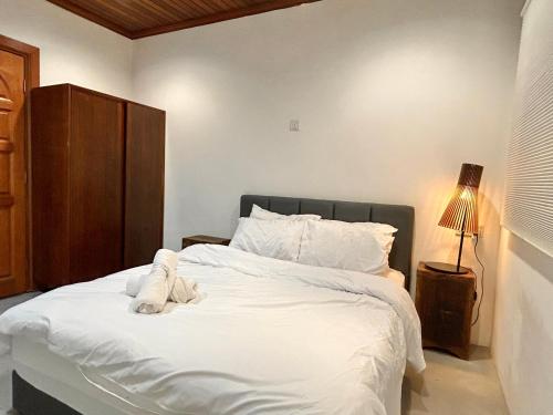 a bedroom with a large bed with white sheets at Chic Designer Bedroom in Shared Bungalow near LRT SS1 PJ in Petaling Jaya